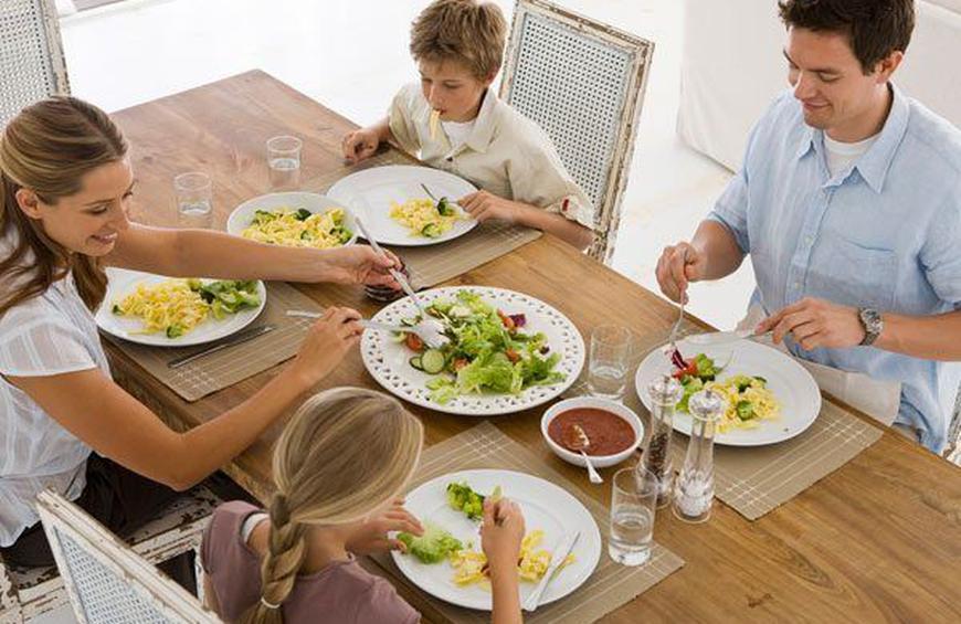 Когда оптимально должен быть последний прием пищи. Семья за обеденным столом. Спокойный прием пищи. Принятие пищи. Люди за столом обед.